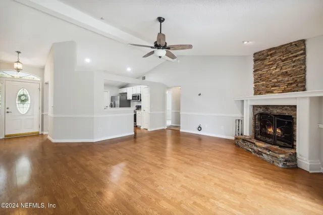 an empty room with windows and fireplace