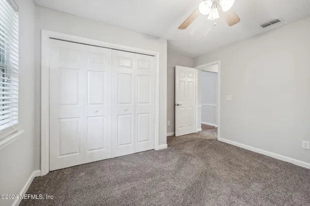 an empty room with a chandelier fan