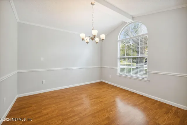 an empty room with windows and ceiling fan