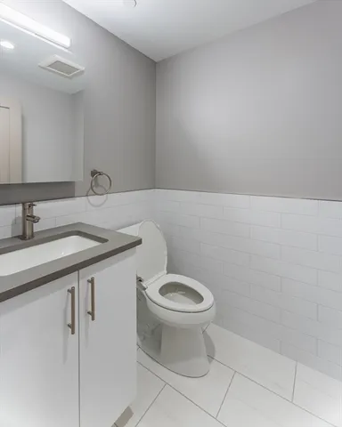 a bathroom with a sink a toilet and a mirror