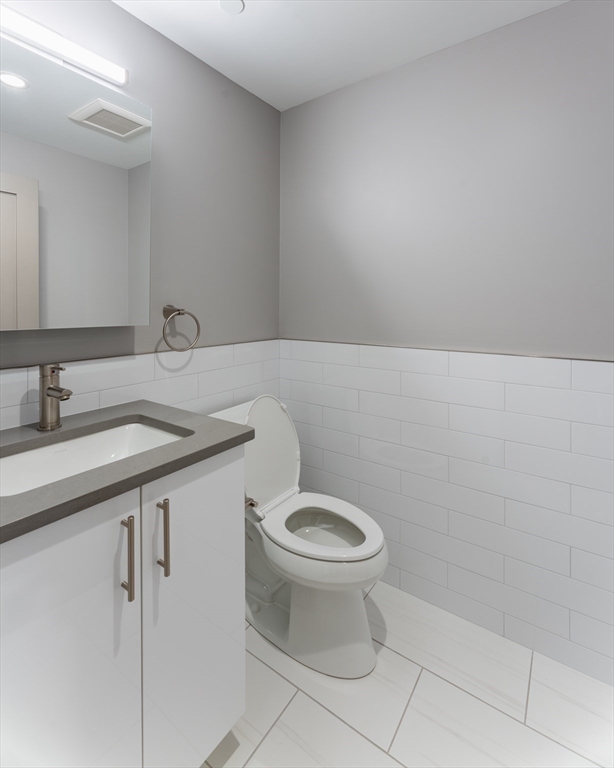 244 Hanover Street, Unit 530 Boston, MA 02113 - Photo 7 of 12 a bathroom with a sink a toilet and a mirror