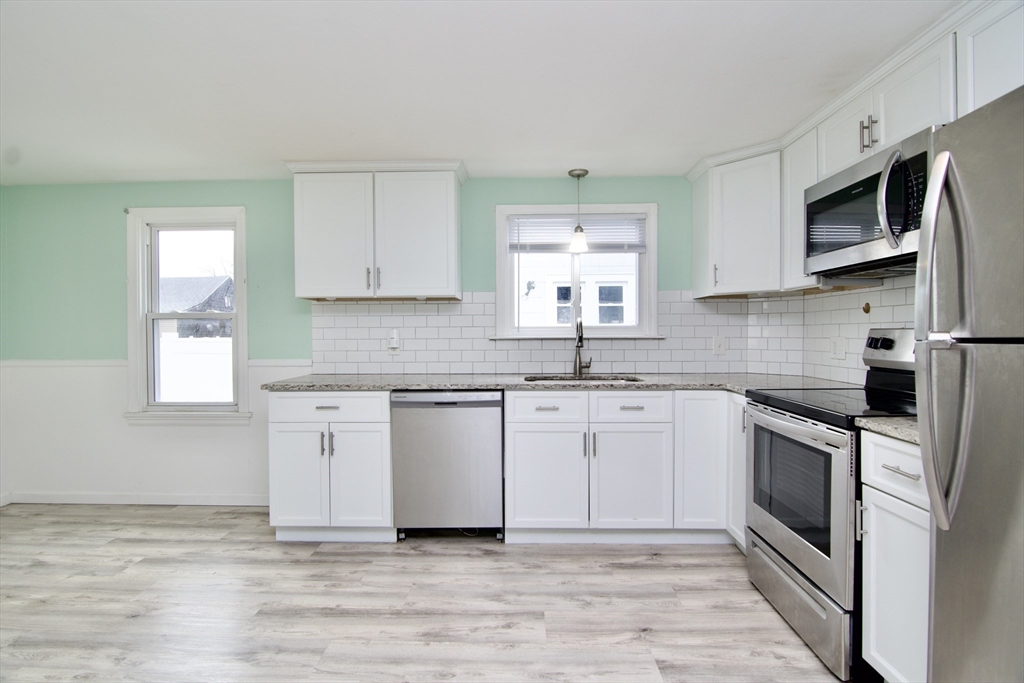 49 Rimmon Avenue Springfield, MA 01107 - Photo 8 of 32 a kitchen with stainless steel appliances granite countertop a sink and a stove top oven