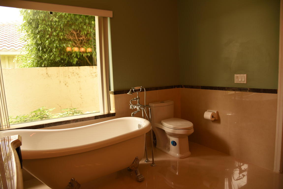 4465 Northwest 28th Way Boca Raton, FL 33434 - Photo 11 of 22 a bathroom with a toilet a sink and a window