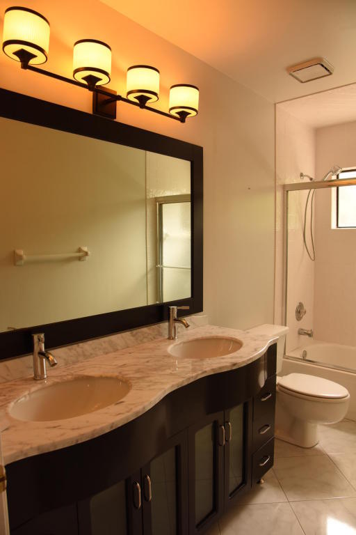 4465 Northwest 28th Way Boca Raton, FL 33434 - Photo 20 of 22 a bathroom with a sink and a mirror