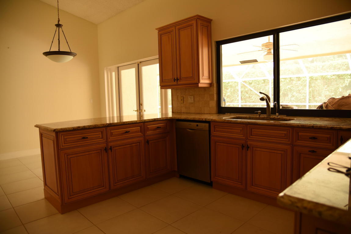 4465 Northwest 28th Way Boca Raton, FL 33434 - Photo 7 of 22 a kitchen with granite countertop wooden cabinets and a granite counter tops