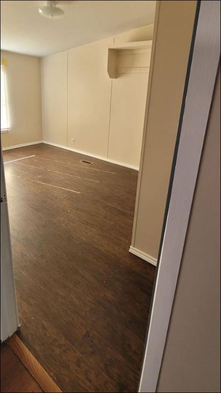404 West Cleveland Street, Unit 1/2 Elgin, TX 78621 - Photo 11 of 23 Empty room with dark wood finished floors and baseboards