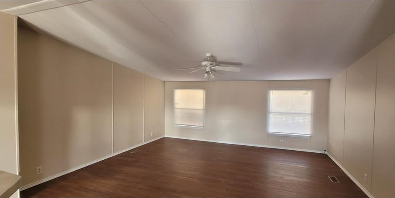 404 West Cleveland Street, Unit 1/2 Elgin, TX 78621 - Photo 19 of 23 Empty room with dark wood-style floors, a decorative wall, and ceiling fan