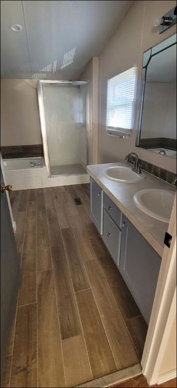 404 West Cleveland Street, Unit 1/2 Elgin, TX 78621 - Photo 23 of 23 Full bath with double vanity, a shower stall, and dark wood-style floors