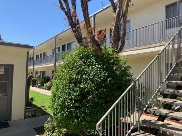 a view of a house with a small yard and potted plants