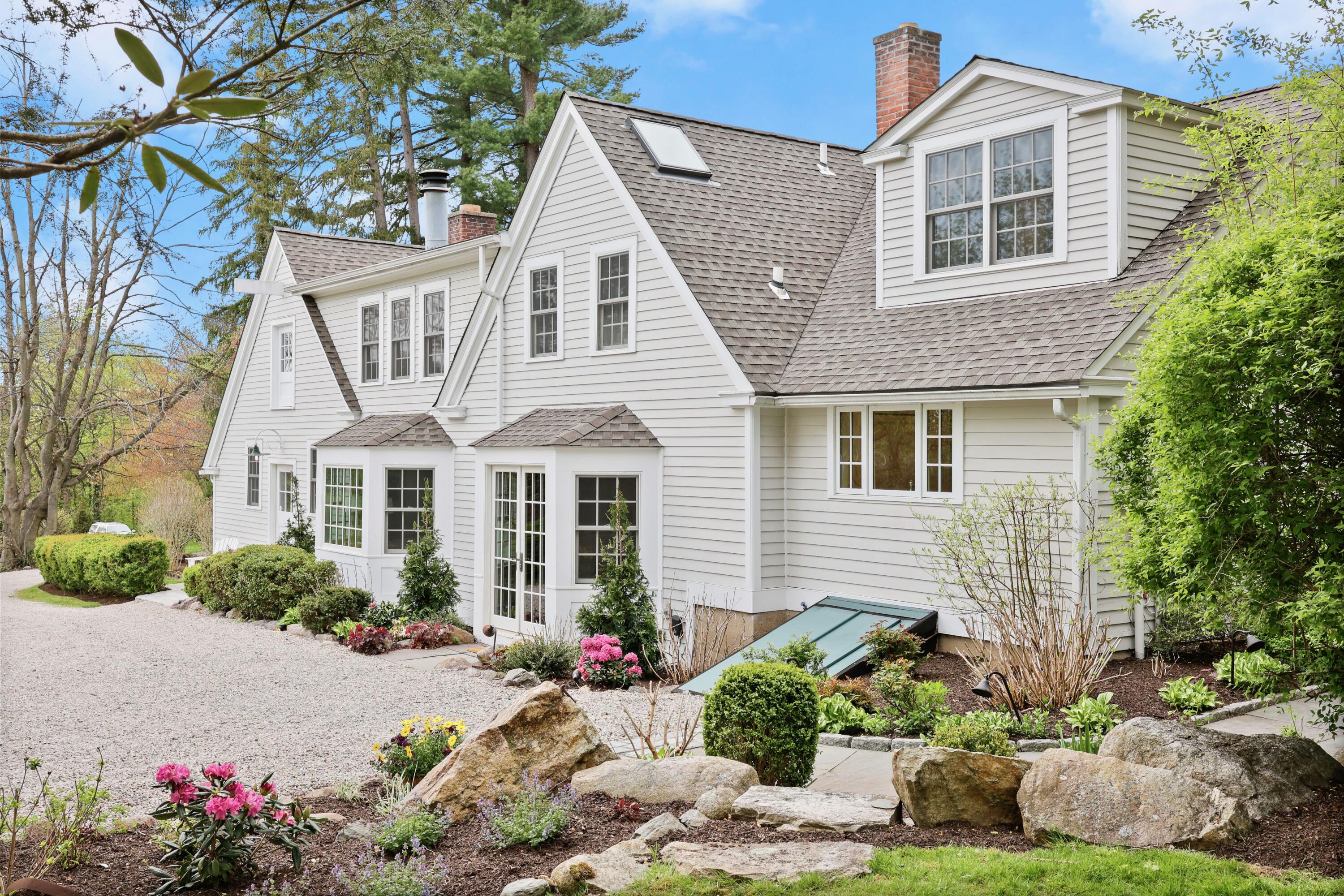 203 Brushy Ridge Road New Canaan, CT 06840 - Photo 2 of 42 a front view of a house with a yard and a garden