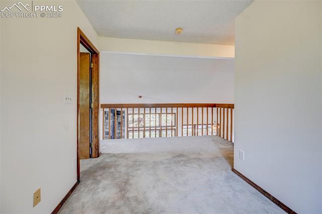 18715 Spring Valley Road Monument, CO 80132 - Photo 23 of 35 Hallway featuring carpet flooring