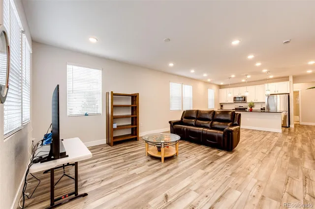 a living room with furniture and a wooden floor