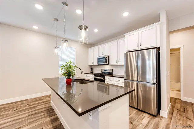 a kitchen with stainless steel appliances granite countertop a refrigerator a sink and a refrigerator