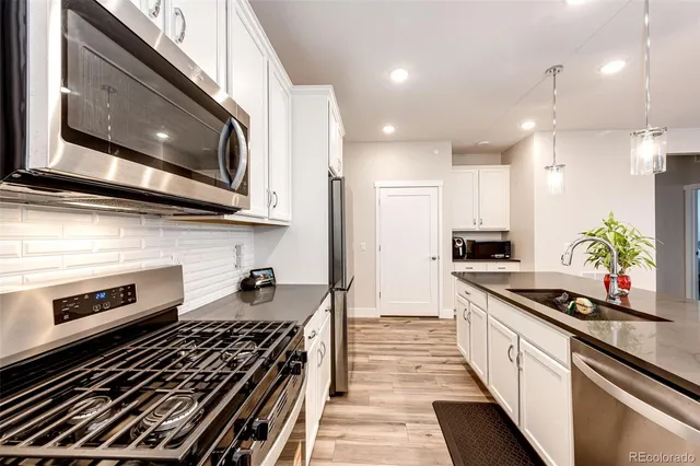 a kitchen with stainless steel appliances kitchen island granite countertop a stove and a microwave