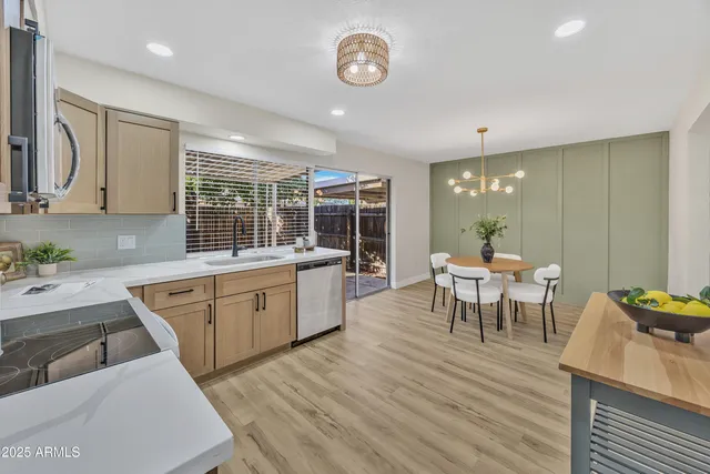 a kitchen with stainless steel appliances granite countertop a sink dishwasher and white cabinets with wooden floor