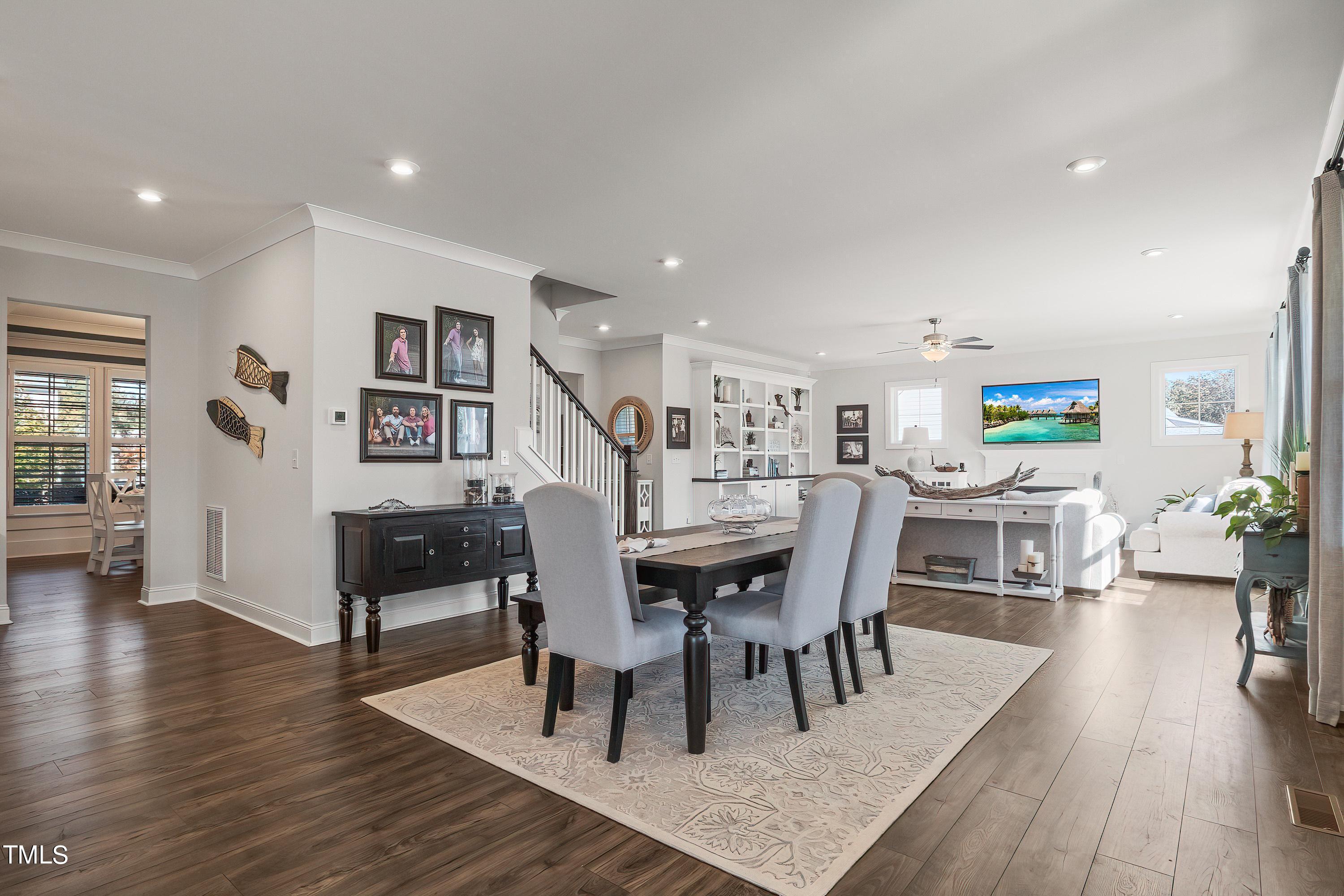 2025 Braeburn Drive Apex, NC 27539 - Photo 13 of 71 a dining room with furniture wooden floor a rug and a painting