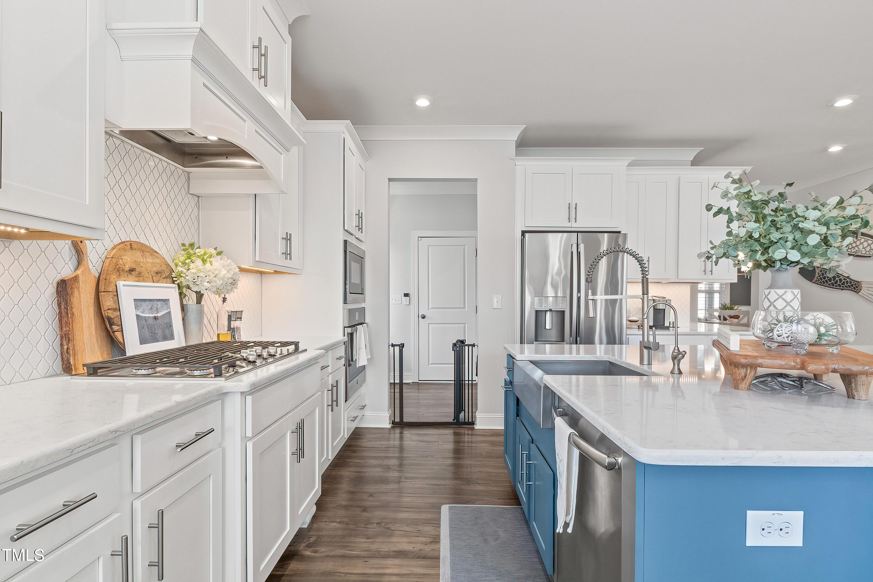 2025 Braeburn Drive Apex, NC 27539 - Photo 19 of 71 a kitchen with stainless steel appliances a sink stove and cabinets