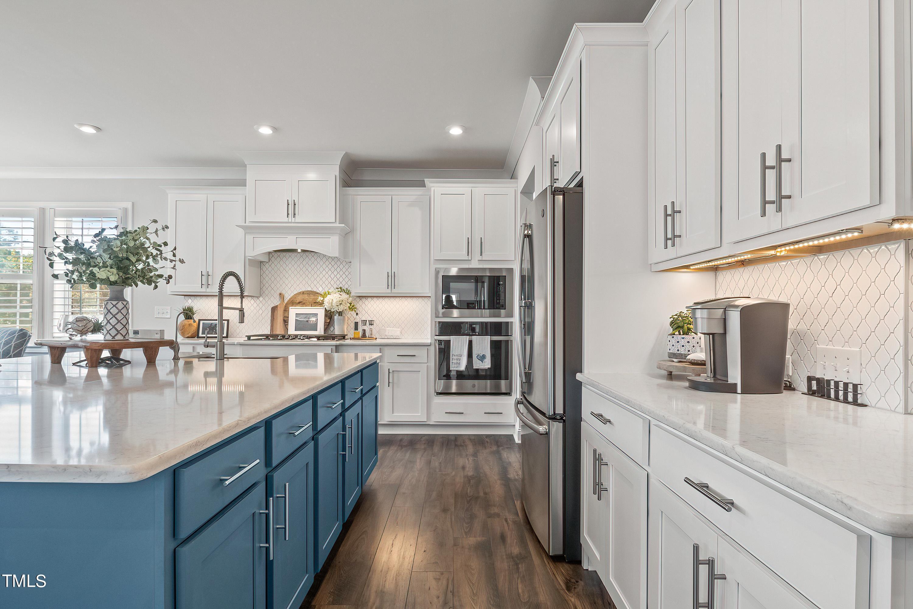 2025 Braeburn Drive Apex, NC 27539 - Photo 20 of 71 a kitchen with kitchen island granite countertop a sink counter top space appliances and cabinets