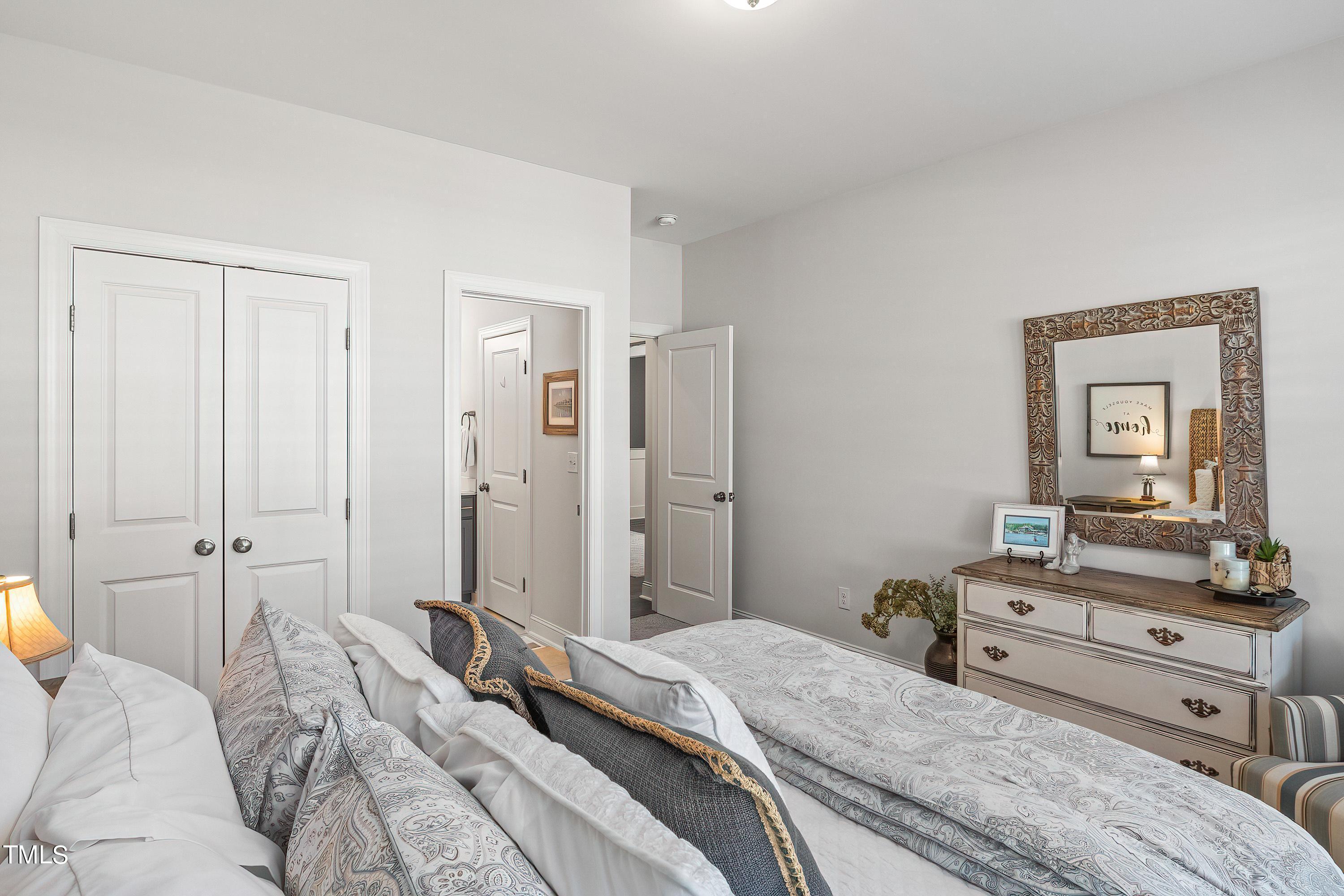 2025 Braeburn Drive Apex, NC 27539 - Photo 29 of 71 a bedroom with a bed and a large mirror