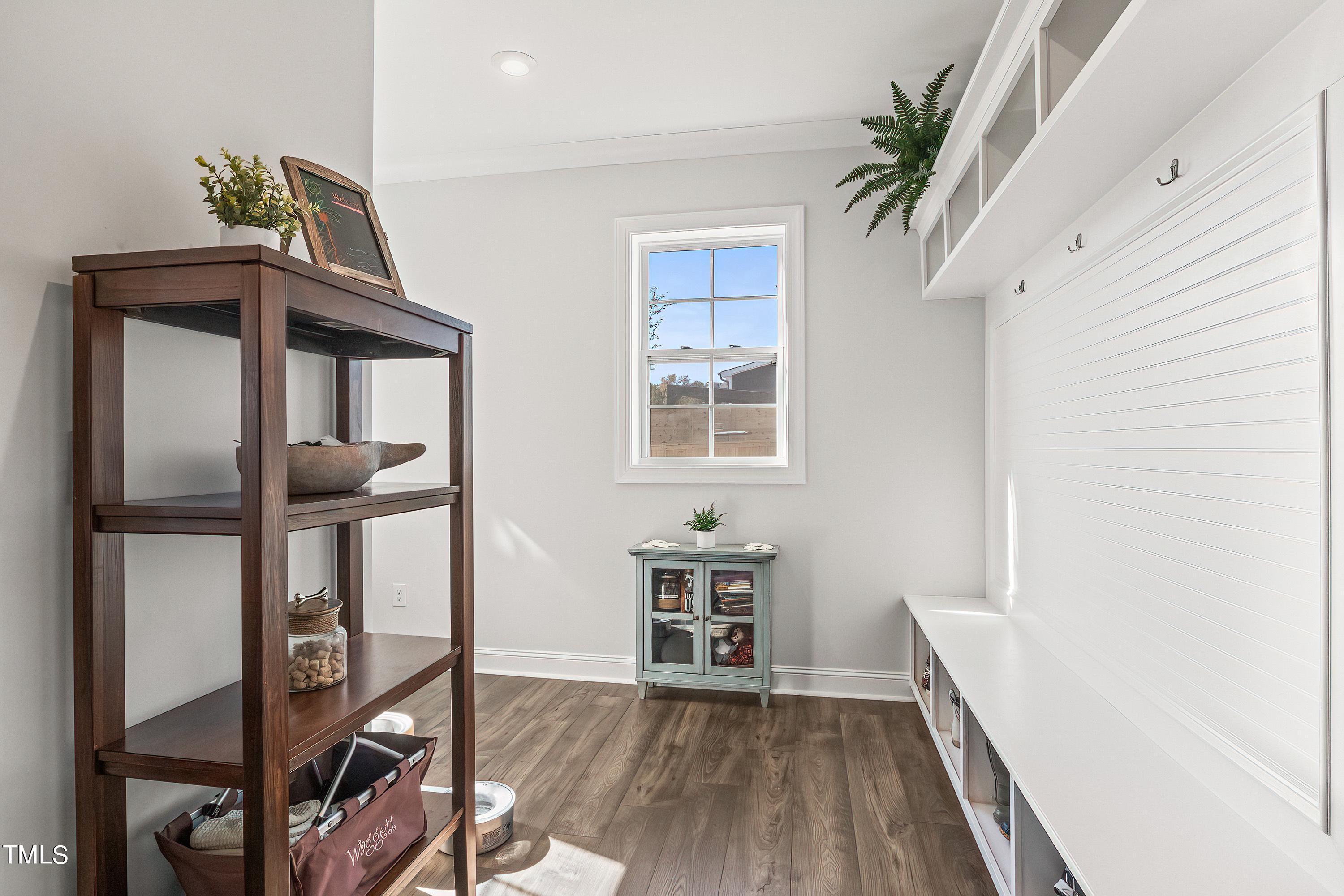 2025 Braeburn Drive Apex, NC 27539 - Photo 30 of 71 a view of a hallway to a livingroom with wooden floor and furniture