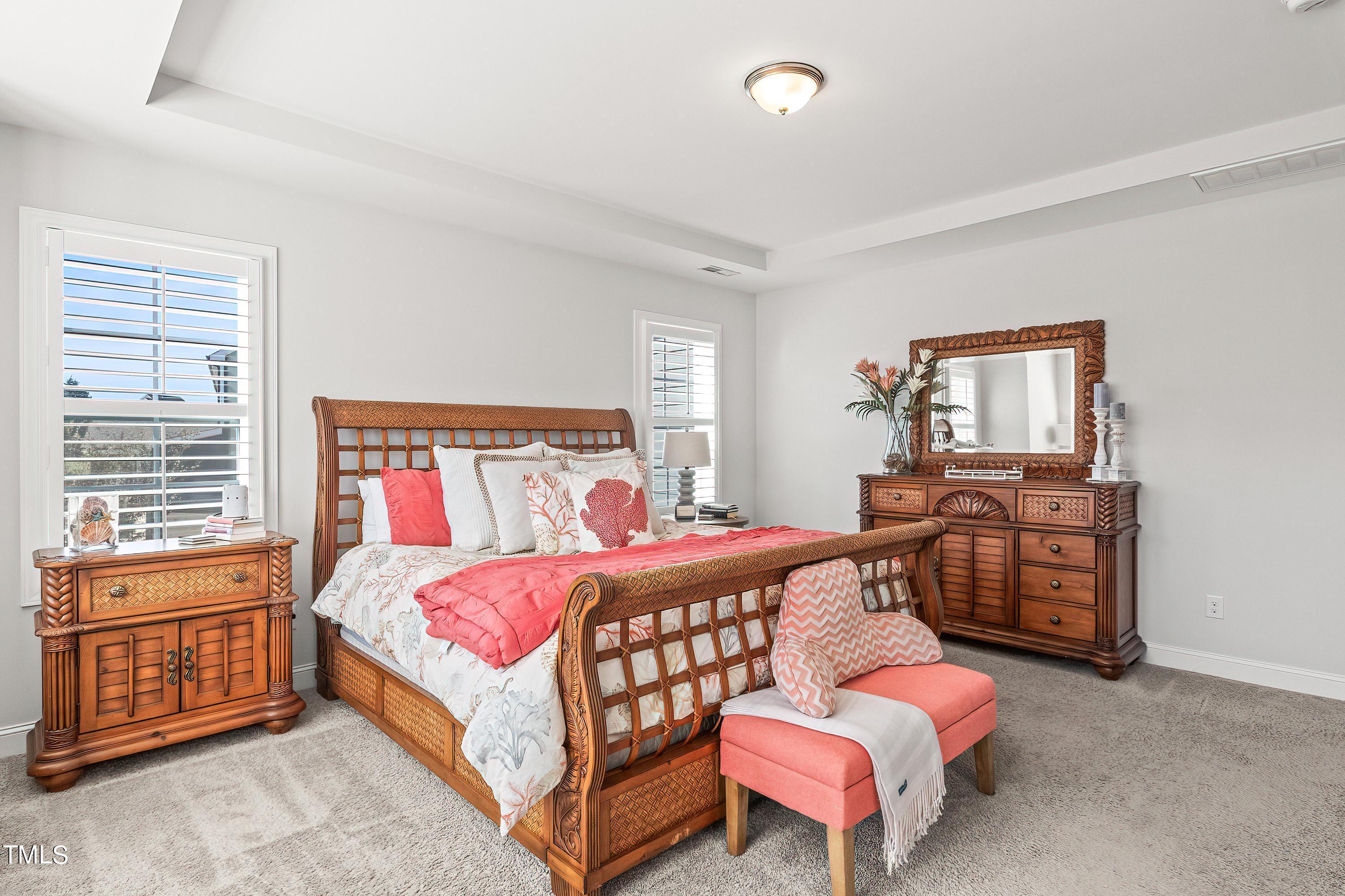 2025 Braeburn Drive Apex, NC 27539 - Photo 33 of 71 a bedroom with a bed and wooden cabinets