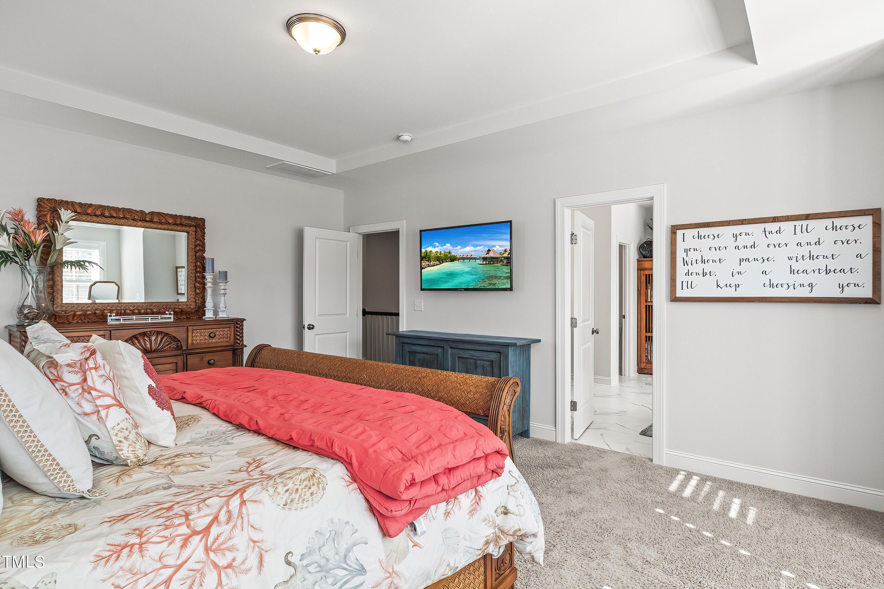 2025 Braeburn Drive Apex, NC 27539 - Photo 34 of 71 a bedroom with a bed and a flat screen tv