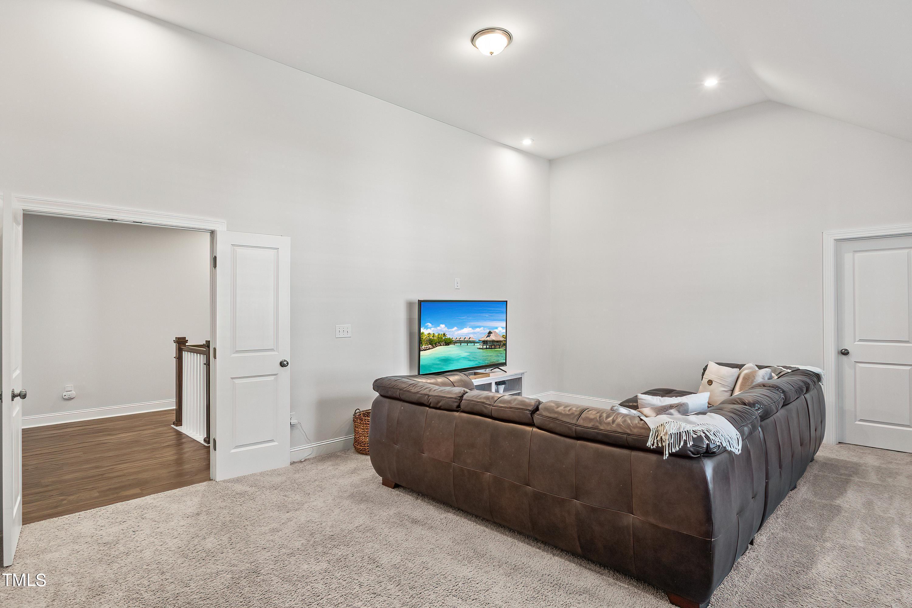 2025 Braeburn Drive Apex, NC 27539 - Photo 41 of 71 a living room with furniture and a flat screen tv