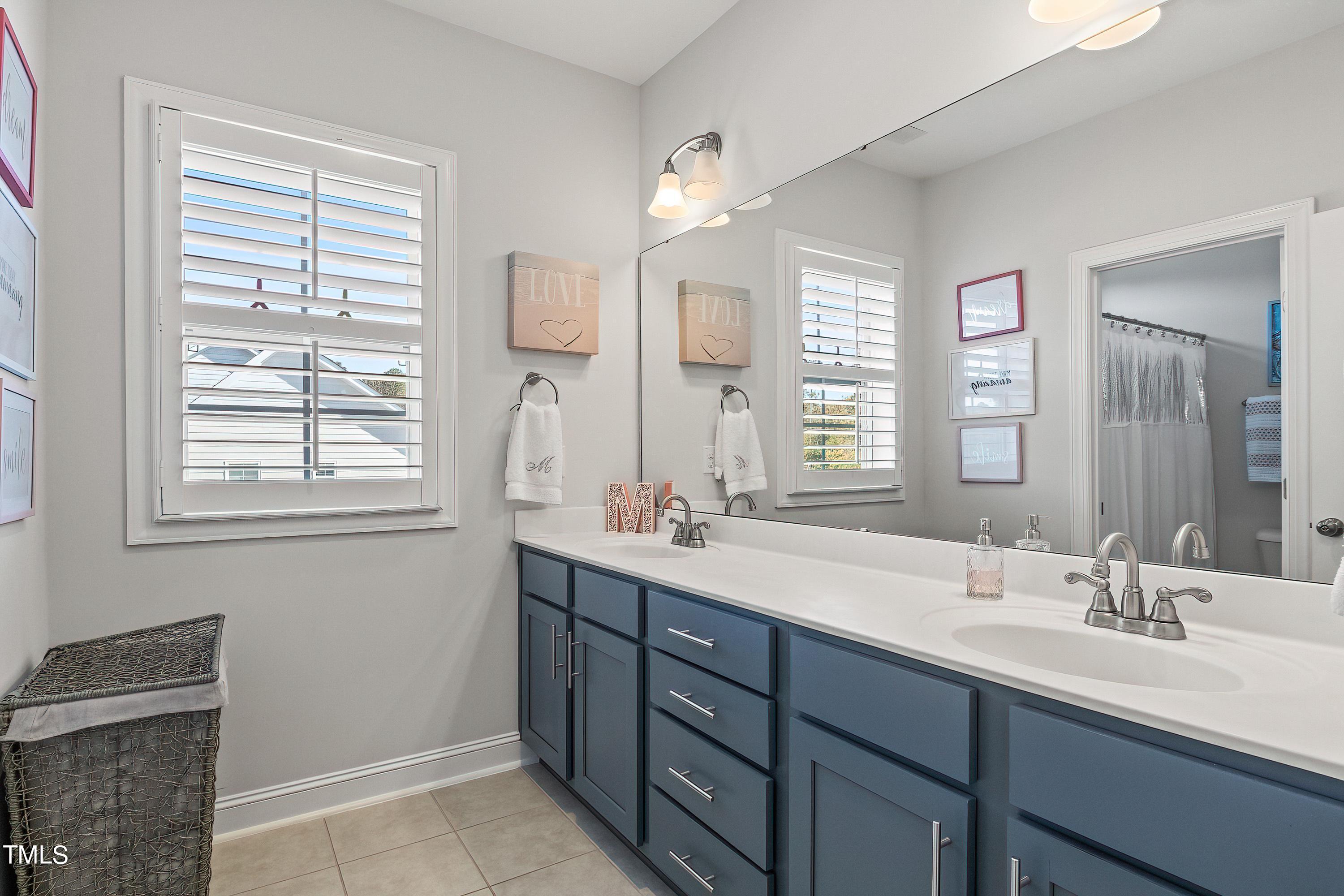 2025 Braeburn Drive Apex, NC 27539 - Photo 45 of 71 a bathroom with double vanity and a mirror