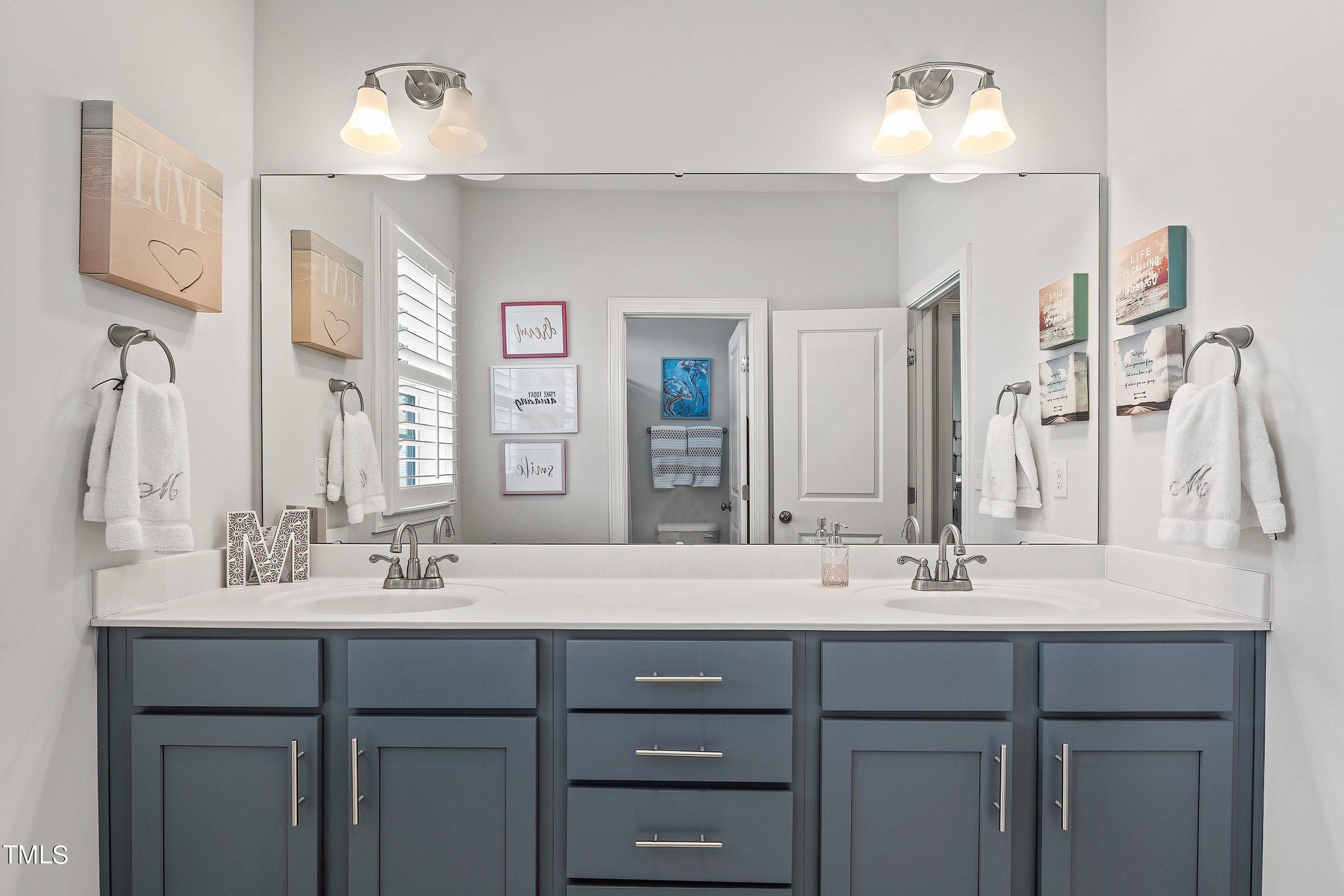 2025 Braeburn Drive Apex, NC 27539 - Photo 46 of 71 a bathroom with a double vanity sink and a mirror