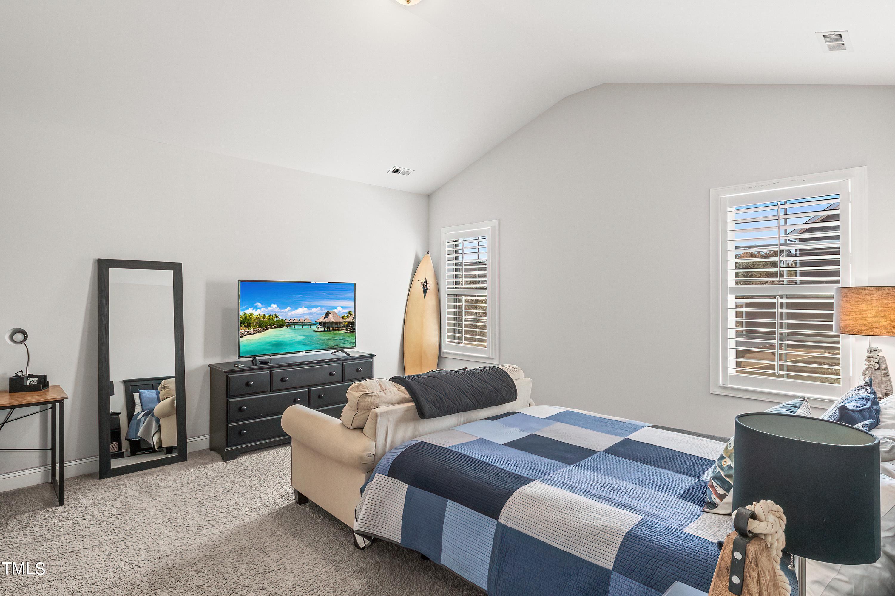 2025 Braeburn Drive Apex, NC 27539 - Photo 52 of 71 a bedroom with bed and a flat screen tv