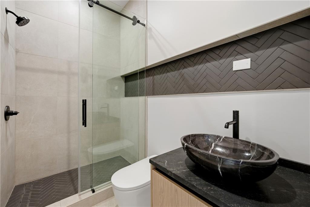 1033 Reeder Circle Northeast Atlanta, GA 30306 - Photo 15 of 52 a bathroom with a granite countertop sink a toilet and shower