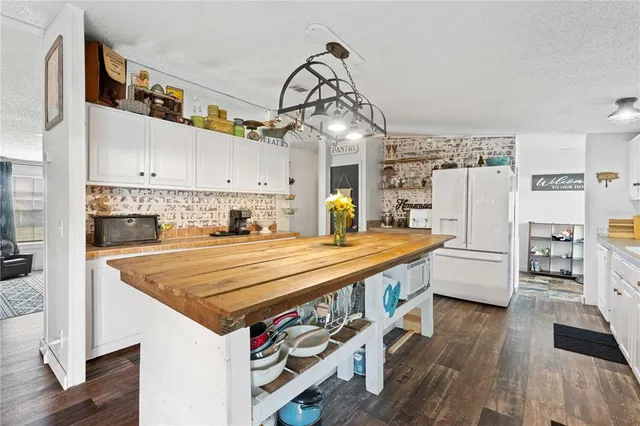 a kitchen with stainless steel appliances granite countertop a stove a sink dishwasher and white cabinets with wooden floor