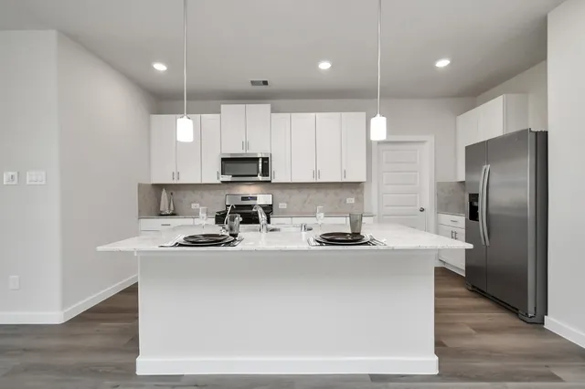 a kitchen with kitchen island a sink stainless steel appliances and cabinets