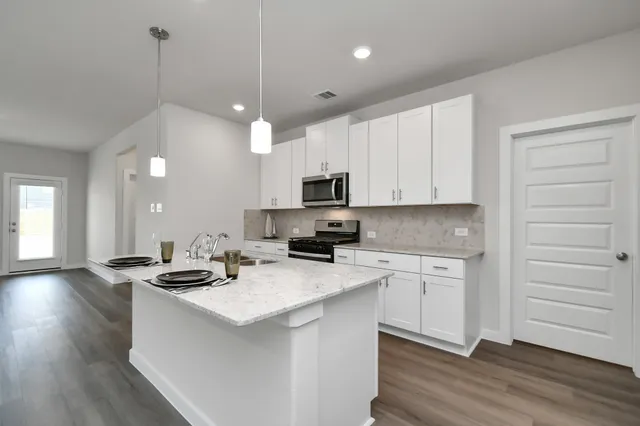 a kitchen with sink stove and wooden floor