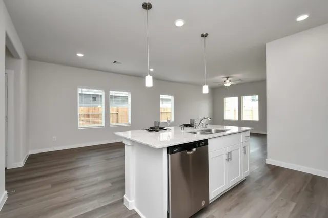 a kitchen with a sink a counter top space stainless steel appliances and cabinets