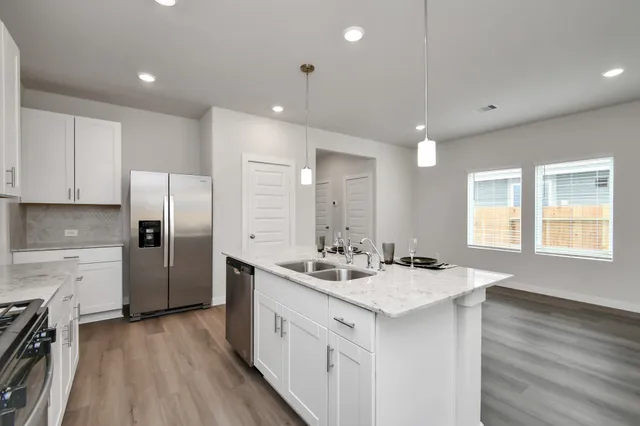 a kitchen with stainless steel appliances granite countertop a sink stove and refrigerator
