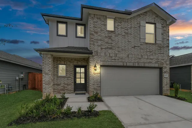 a front view of a house with a garden and plants