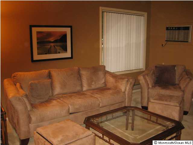 98 Arrowood Road, Unit C Manalapan, NJ 07726 - Photo 2 of 3 a blue couch sitting next to a window
