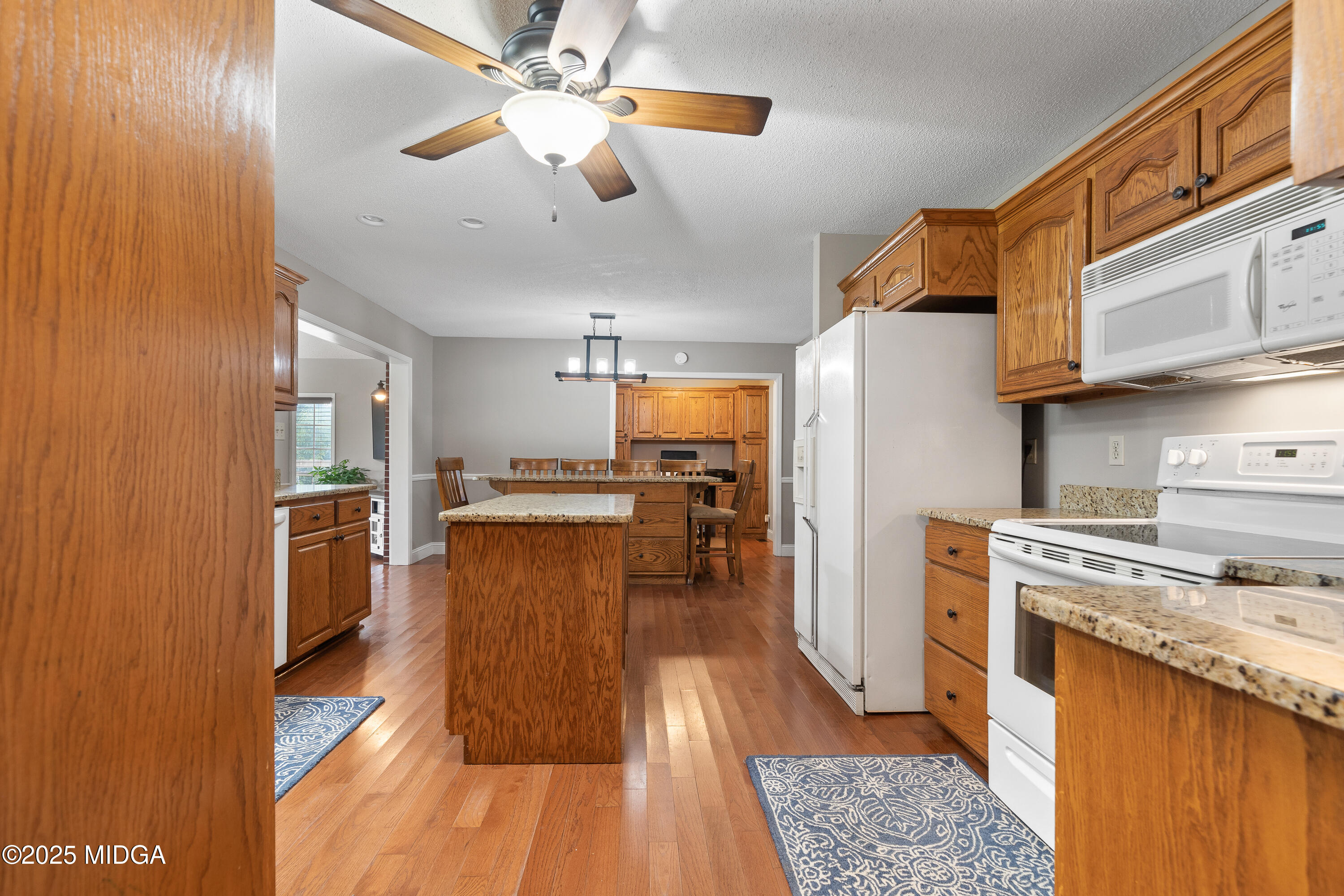 299 Colvin Road Forsyth, GA 31029 - Photo 16 of 51 a kitchen with stainless steel appliances granite countertop a refrigerator a oven a stove and a sink with wooden floor