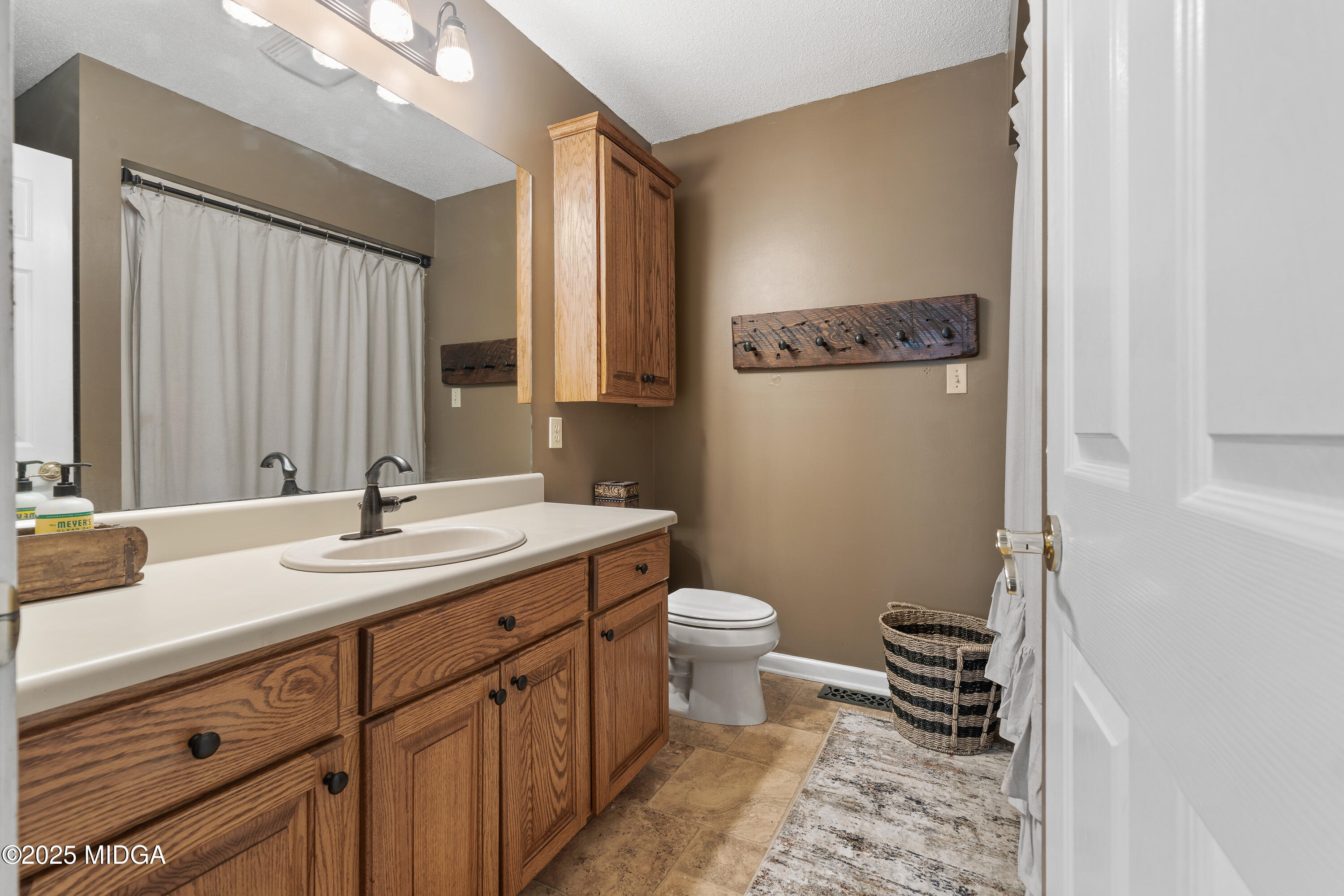 299 Colvin Road Forsyth, GA 31029 - Photo 23 of 51 a bathroom with a sink a toilet a mirror and shower