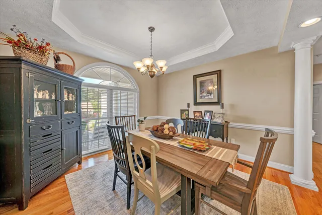 a view of a dining room with furniture wooden floor and chandelier
