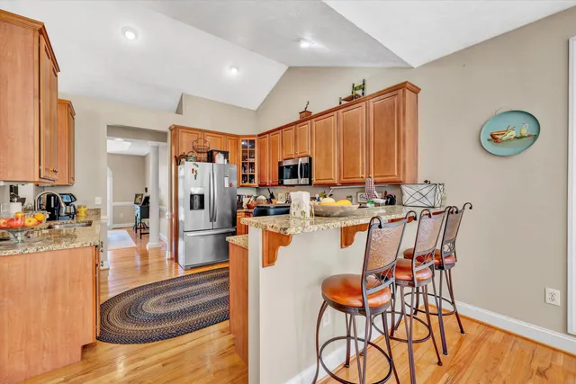 a dining hall with stainless steel appliances granite countertop a stove and a refrigerator with cabinets