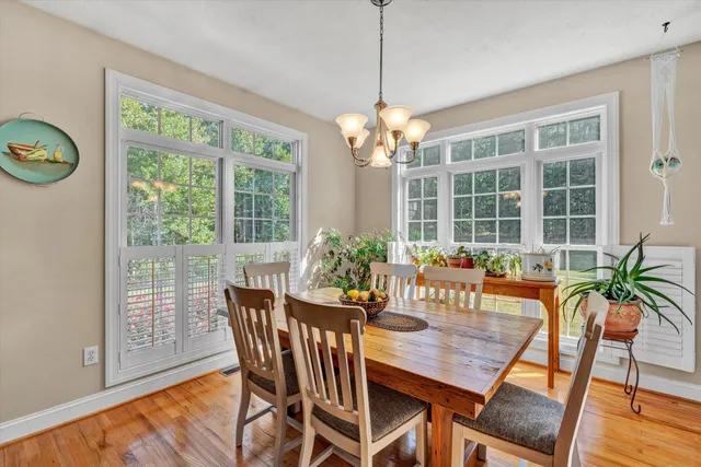 a dining room with furniture a large window and wooden floor