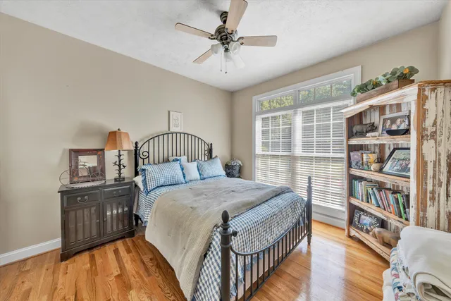 a bedroom with a bed a book shelf and a window