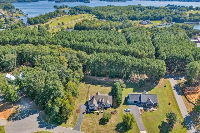an aerial view of a house with a yard and lake view