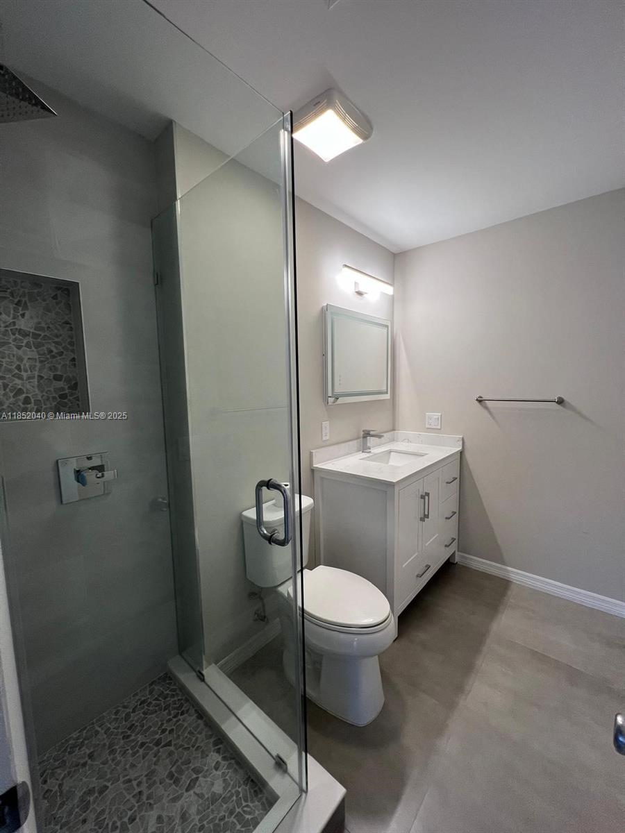 2175 Northeast 56th Street, Unit 211 Fort Lauderdale, FL 33308 - Photo 11 of 15 a bathroom with a toilet sink and mirror