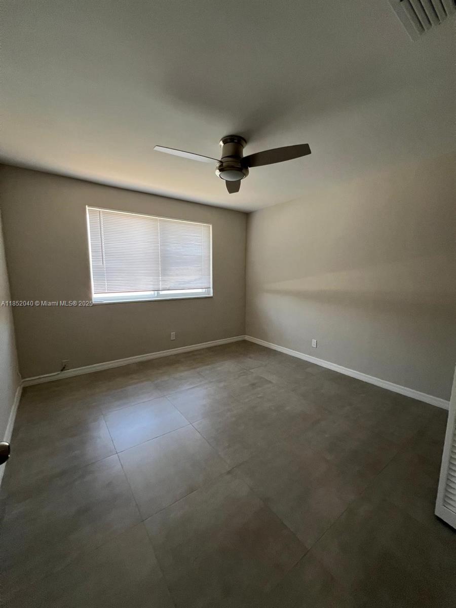 2175 Northeast 56th Street, Unit 211 Fort Lauderdale, FL 33308 - Photo 13 of 15 en empty room with windows and ceiling fan