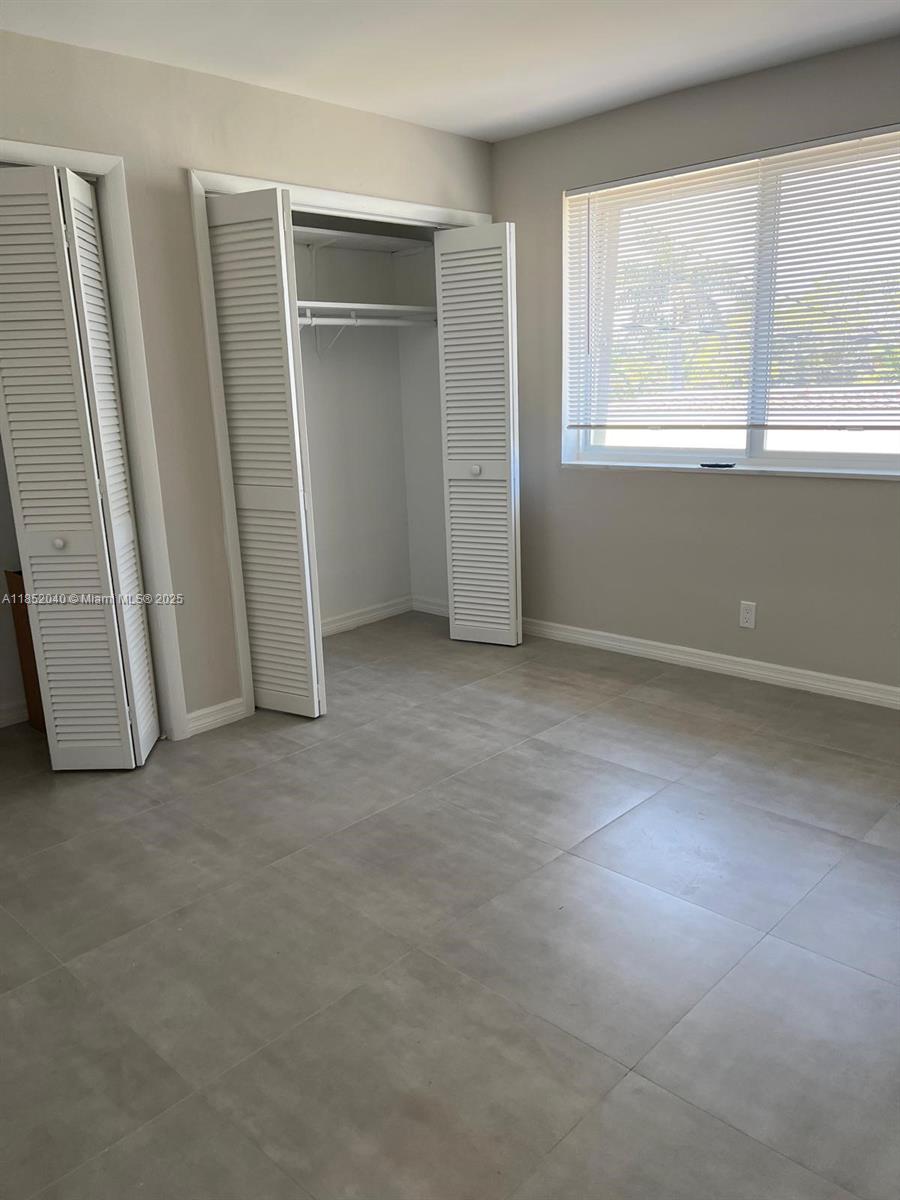 2175 Northeast 56th Street, Unit 211 Fort Lauderdale, FL 33308 - Photo 15 of 15 an empty room with windows and closet