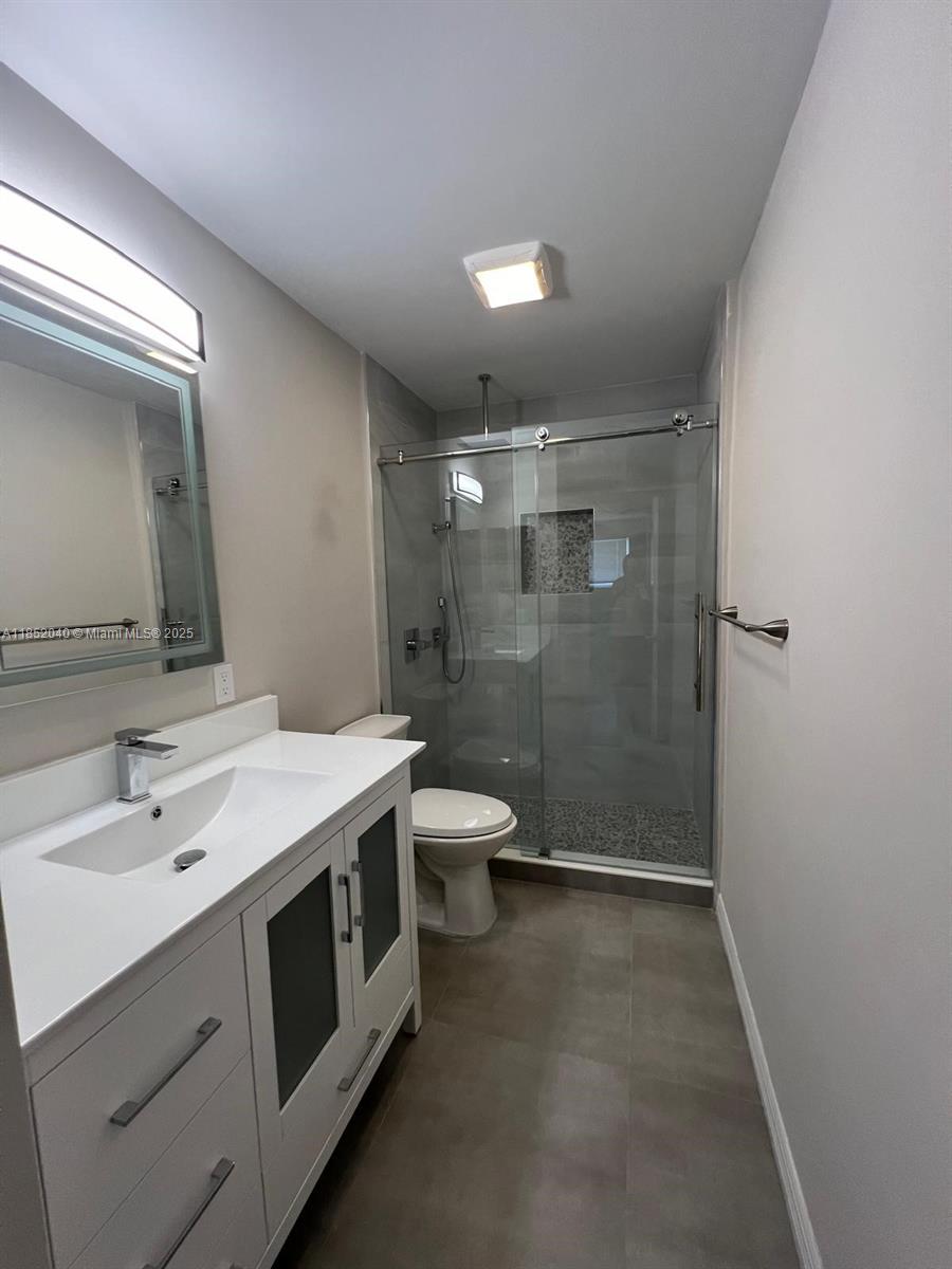 2175 Northeast 56th Street, Unit 211 Fort Lauderdale, FL 33308 - Photo 7 of 15 a bathroom with a double vanity sink toilet and shower