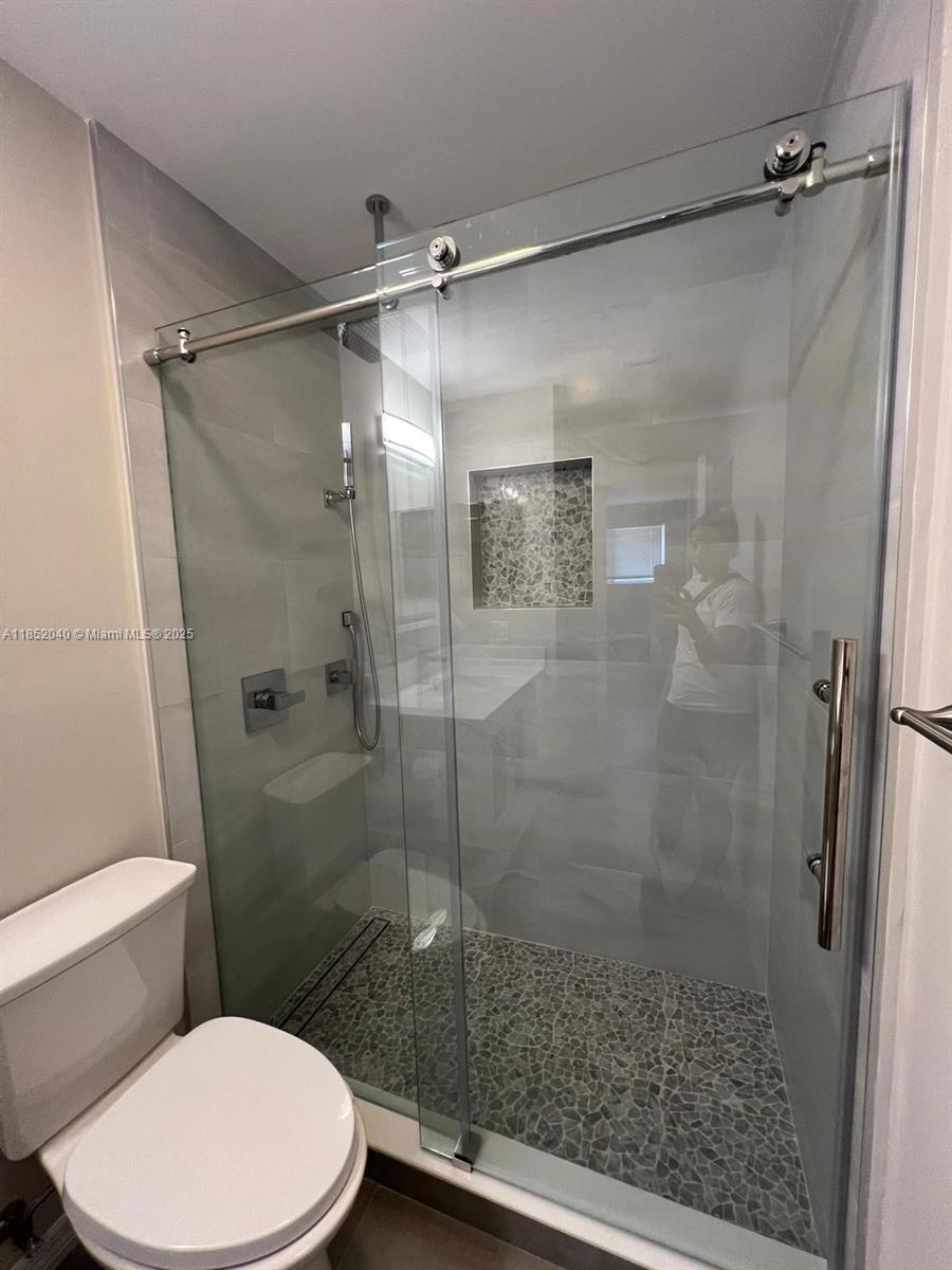 2175 Northeast 56th Street, Unit 211 Fort Lauderdale, FL 33308 - Photo 8 of 15 a bathroom with a toilet and a shower